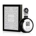 A bottle of Lattafa Fakhra Alahafa perfume next to its black presentation box, both featuring silver Arabic calligraphy and ornate patterns on a white background.